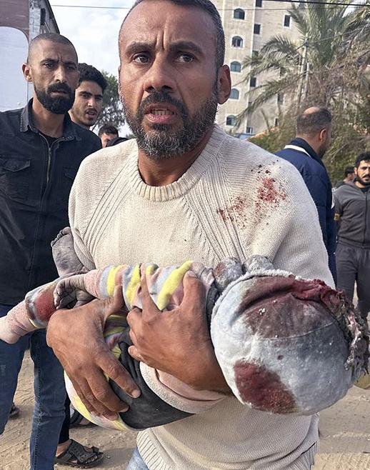 Man carrying a wounded Palestinian child