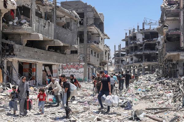 Palestinians walk through destruction after Israeli bombing of the Jabalya refugee camp in Gaza, May 30, 2024.