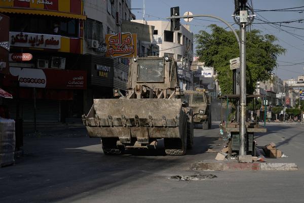An Israeli bulldozer and an armored vehicle move on a street during a raid in Jenin, in the West Bank, June 6, 2024.