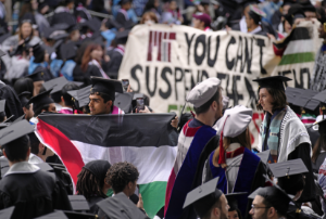 A graduating student carries the Palestinian flag while walking out of commencement in protest at the Massachusetts Institute of Technology, Thursday, May 30, 2024,