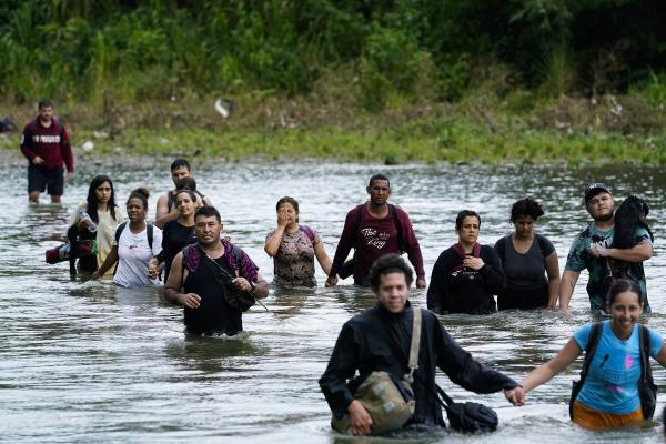 Migrants, mostly from Venezuela, cross the Tuquesa river after trekking through the Darien Gap, October 4, 2023.