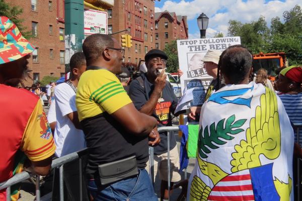 Carl Dix agitating to crowd of people at the New York City Caribbean Day parade.