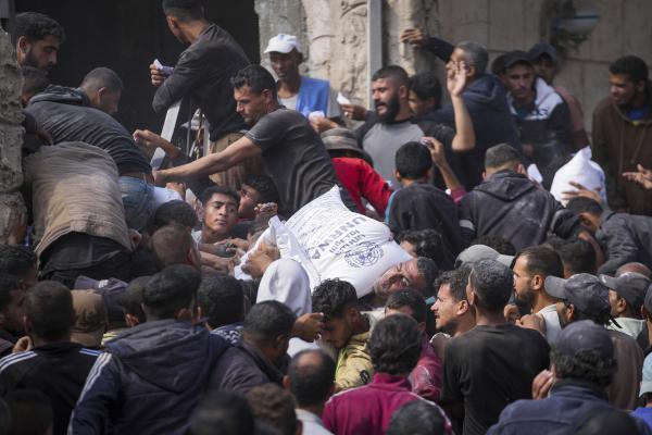 Palestinians receive bags of flour distributed by UNRWA, the U.N. agency helping Palestinian refugees, in Deir al Balah, central Gaza Strip, November 2, 2024.