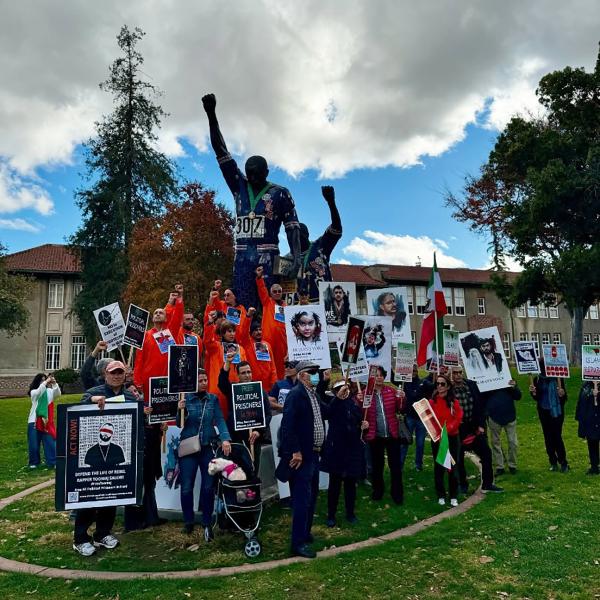 November 23, 2024: Protesters at San Jose State University in California demand an end to executions and freedom for political prisoners in Iran while grouped around a huge statue of the iconic raised fists of Black athletes Tommie Smith and John Carlos at the 1968 Olympics.