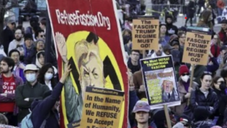Refuse Fascism Hitler banner in middle of protest. "In the name of humanity, we refuse to accept a fascist America. 
