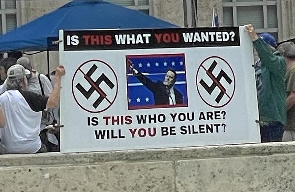 Sign: "Is This What You Wanted?" with picture of Elon Musk and swastikas. Houston..