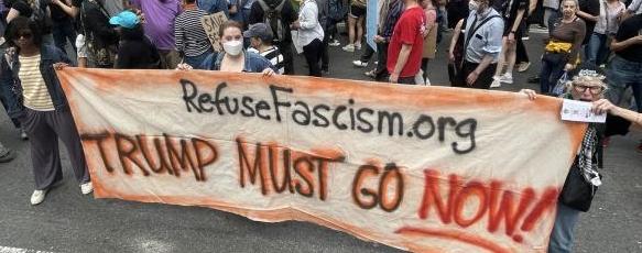 Banner at protest: Refuse Fascism - Trump Must Go Now!