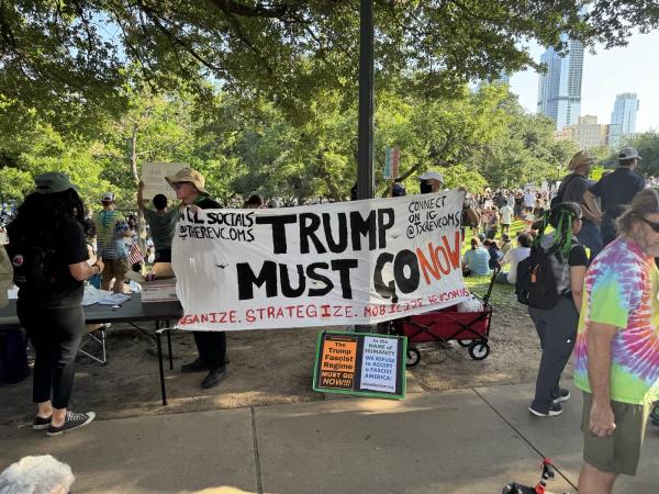 At the Houston No Kings protest: Trump Must Go Now banner.