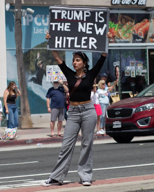 Huntington Beach woman holding sign: "Trump is the new Hitler."