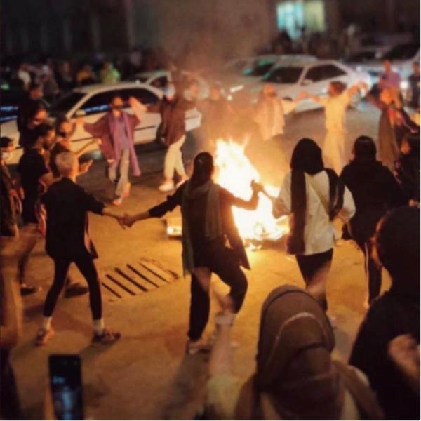 Women dance around a bonfire of burning headscarves, Bandar Abbas, Iran, September 22, 2022. 