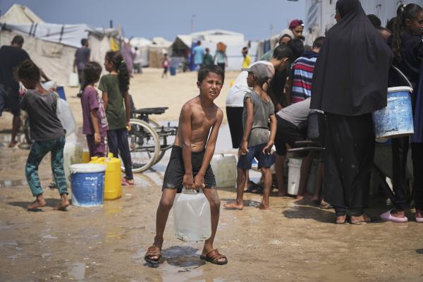 Boy struggles to carry water, August 13, 2025.