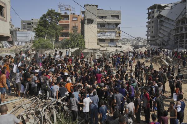 Palestinians struggle to collect humanitarian aid air-dropped into Gaza City, August 14, 2025.