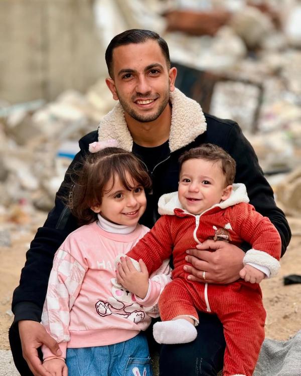 Murdered journalist Anas Al-Sharif holding his two children