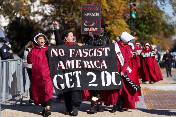Handmaids with banner that says "Get Fascist America. Get 2 DC" in Washington, DC, November 5, 2025.