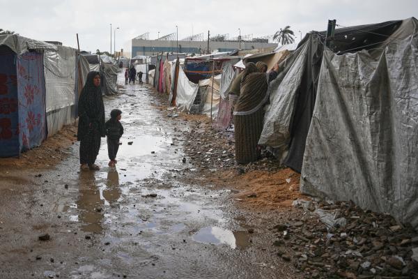  Mother and child examine damage from flooding at a tent camp in the central Gaza Strip, November 14, 2025.