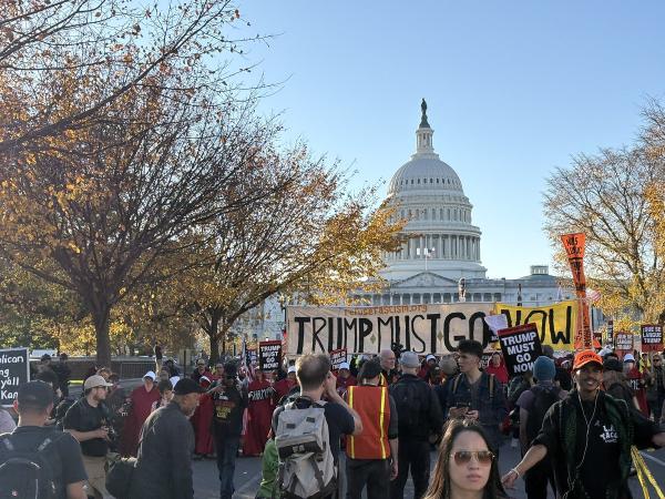 Crowd with Trump Must Go Now banner in front of capitol building, November 5, 2025.