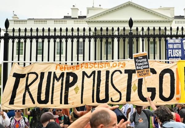Refuse Fascism banner "Trump Must Go Now" in front of the White House gates.