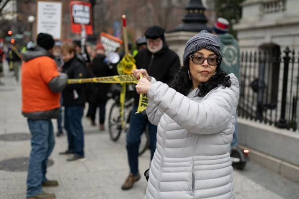 Woman at Surround the White House 2.0 with crime tape.