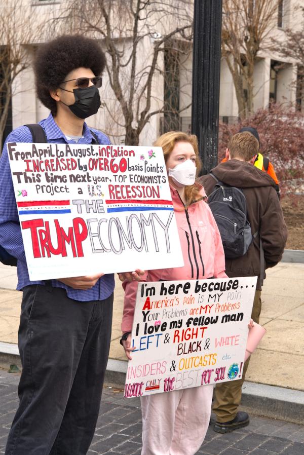 A couple with signs at Surround the White House 2.0, December 13, 2025