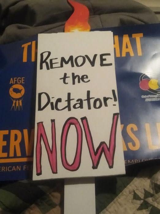 Hand made sign "Remove the Dictator NOW"