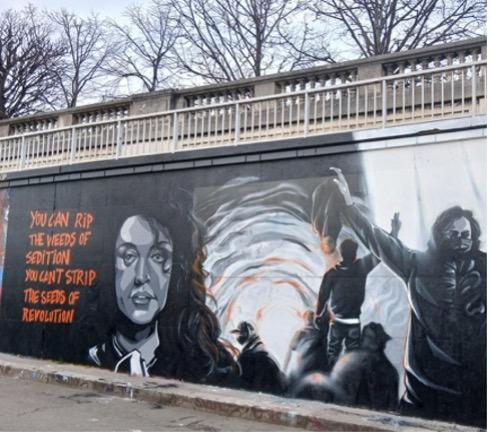 Part of a mural on a Paris street featuring Narges Mohammadi and scenes from the Woman, Life, Freedom uprising of 2022.