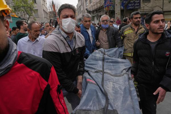 A victim is carried from a residential building hit by U.S.-Israeli airstrike on Tehran, March 27, 2026.