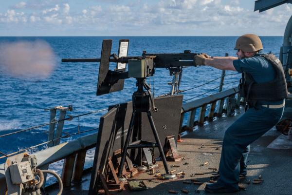 Navy officer firing a machine gun from destroyer in the Mediterranean Sea, April 6, 2026.