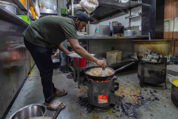 Preparing food over a charcoal stove due to a shortage of liquefied petroleum gas in Mumbai, India, March 11, 2026.