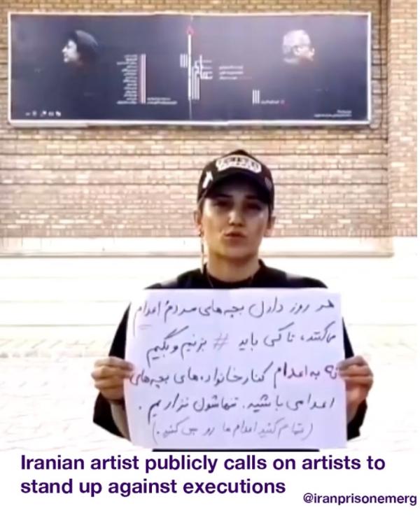 Iranian artist holds a sign to stop the executions of Iran prisoners.