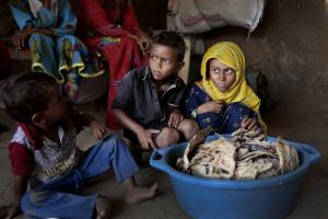 Children sit around moldy bread at shelter in Yemen.