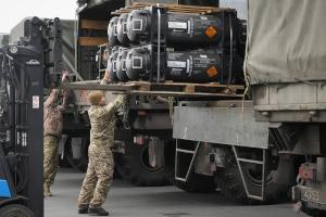 Ukrainian servicemen load weaponry from the U.S. into trucks.