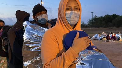 Mother holds her 9 year old as they wait for Border Patrol to take them into custody.