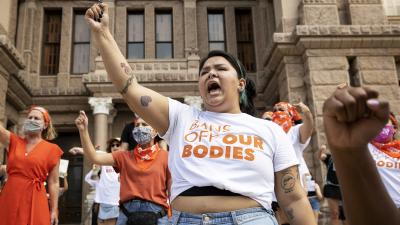 Women protest Texas six-week ban on abortion on Austin capitol steps.