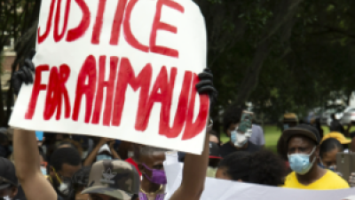 Woman holding sign "Justice for Ahmaud"