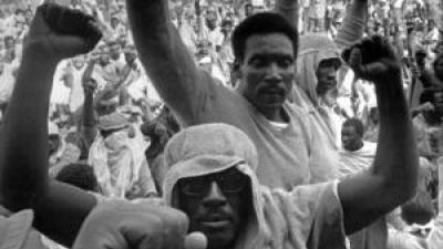 Attica prisoners with fists in the air.