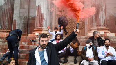 Scientists Rebellion activists with red smoking flares in front of the National Congress, Madrid, Spain