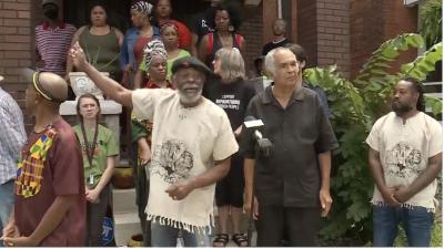 Omali Yeshitela, leader of the African People's Socialist Party, points to damage done in the FBI raid on his home.