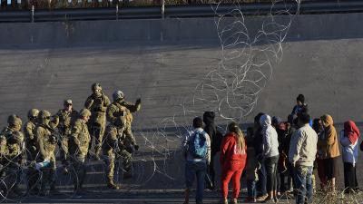 Immigrants stopped by Border Patrol and barbed wire at U.S. Mexico border, December 20, 2022.