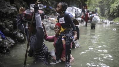 Haitian migrants wade through water as they cross the treacherous Darien Gap from Colombia to Panama.