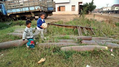Children play near cluster bombs in Laos, 1997.