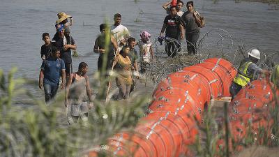 Migrants from Mexico stopped from crossing the Rio Grande by barbed wired buoys