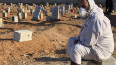 A grieving man sits by graves of flash flood victims in Derna, Libya, Friday, Sept. 15, 2023.