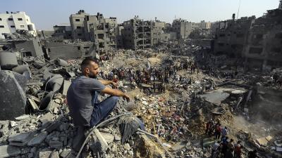 A man sits on the rubble as Palestinias search rubble in Jabaliya refugee camp, northern Gaza Strip, after Israeli airstrike, November 1, 2023.