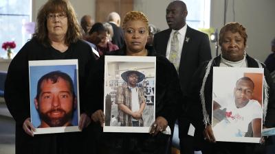 Three mothers hold pictures of their sons whose bodies were buried in unmarked graves without any notification.