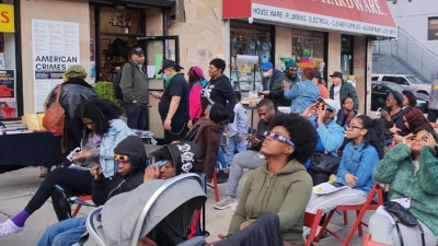 People outside Revolution Books NYC watching the eclipse: “The Eclipse Party at the Bookstore that Has the Whole World in Mind.”