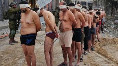 Stripped, blindfolded, and bound Palestinian civilians are taken prisoner and ordered into a line by Israeli occupation forces in Gaza in December 2023