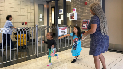 An immigrant from Venezuela plays with her children. They are living in the Chicago Police Department’s 16th District station, May 1, 2023.