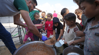 Displaced Palestinian children line up for food in a camp in Deir al-Balah, Gaza, October 18, 2024.