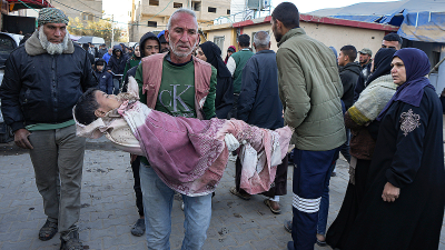 A Palestinian child wounded during the Israeli bombardment of the Gaza Strip is carried to Al-Aqsa Hospital, December 19, 2024.