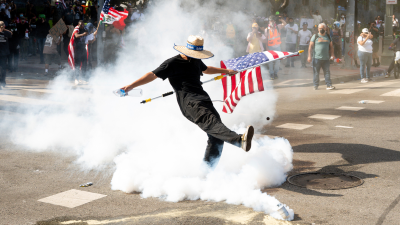 A demonstrator kicks a canister of tear gas during a Los Angeles protest, June 14, 2025.